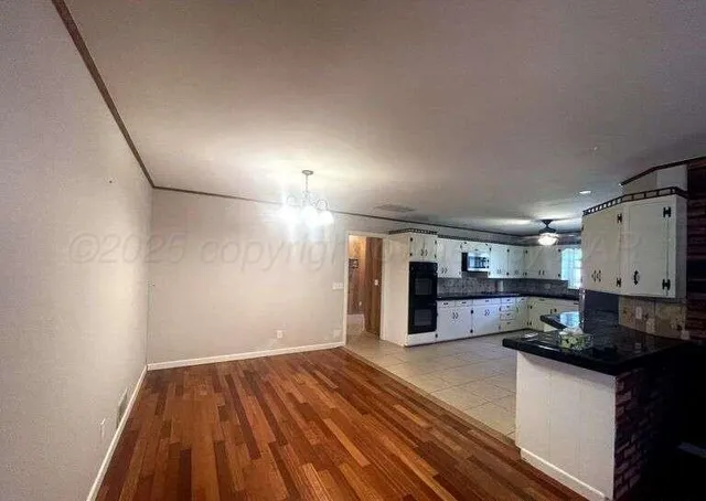 a kitchen with granite countertop white cabinets and stainless steel appliances