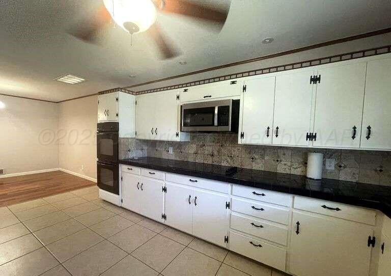 1401 Maple Avenue Panhandle, TX 79068 - Photo 28 of 42 a kitchen with granite countertop white cabinets and stainless steel appliances