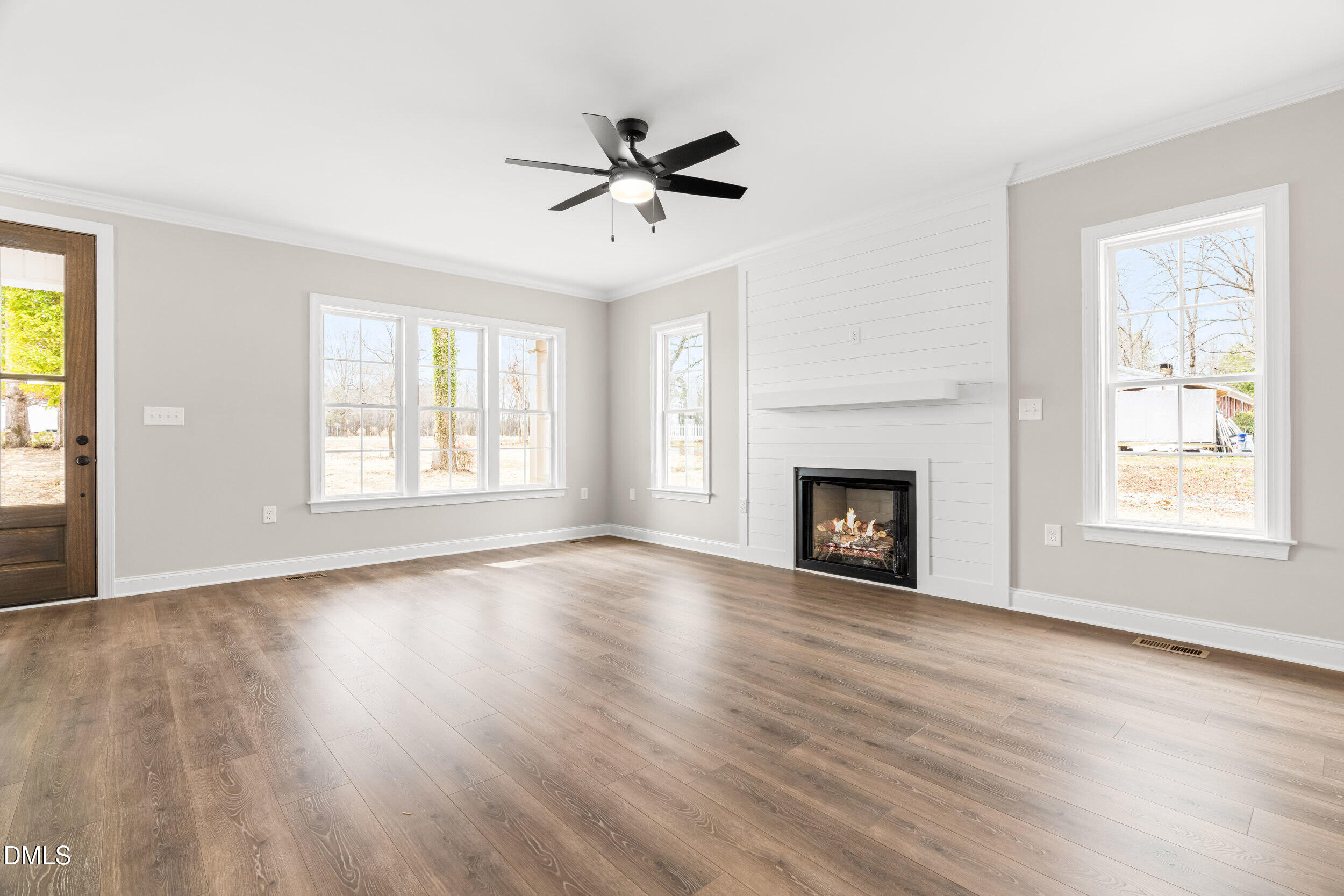 4029 Lake Wendell Road Wendell, NC 27591 - Photo 11 of 44 a view of an empty room with wooden floor fireplace and a window