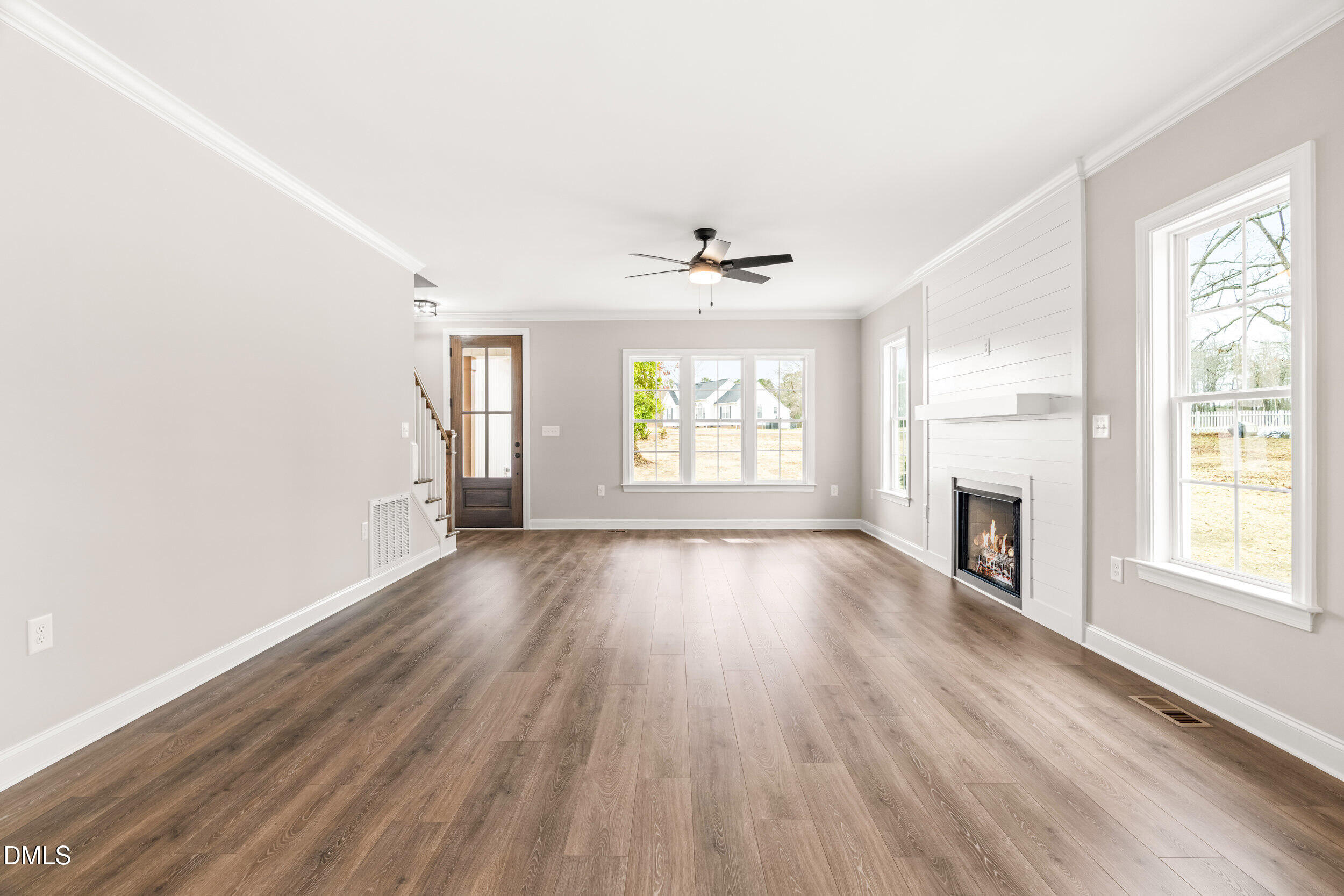4029 Lake Wendell Road Wendell, NC 27591 - Photo 12 of 44 an empty room with windows a fireplace and wooden floor