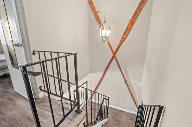 a view of staircase with wooden floor and white walls
