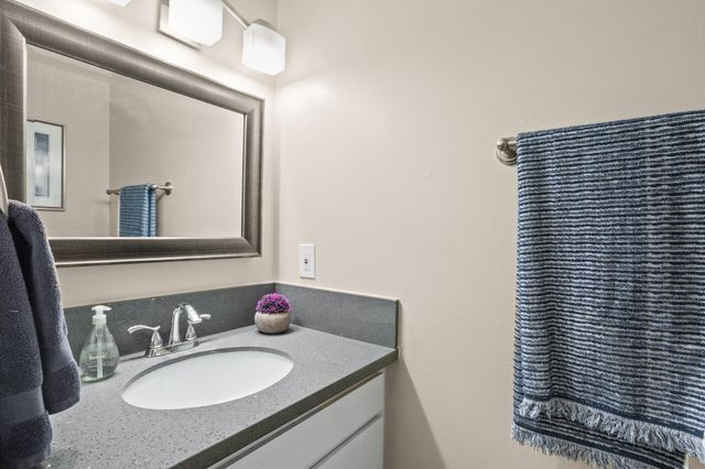 a bathroom with a granite countertop sink and a mirror