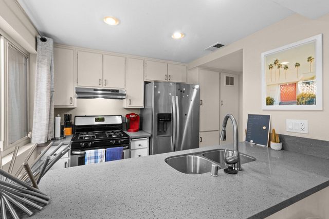 a kitchen with stainless steel appliances a sink and a refrigerator