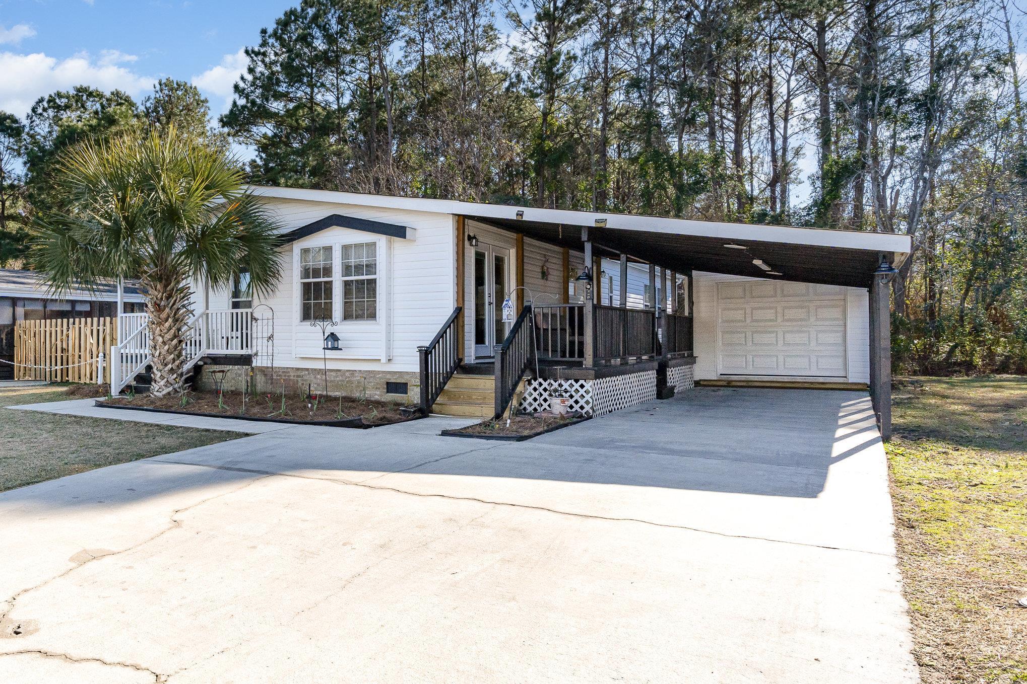 View of front facade with concrete driveway, crawl space, and an attached carport