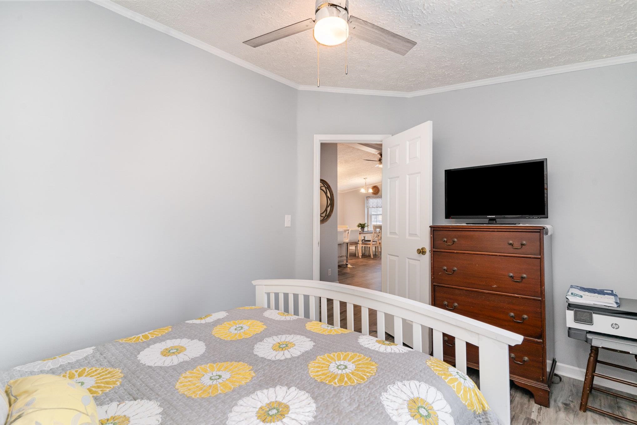 706 Oliver Drive Murrells Inlet, SC 29576 - Photo 17 of 29 Bedroom featuring a textured ceiling, wood finished floors, ornamental molding, and a ceiling fan
