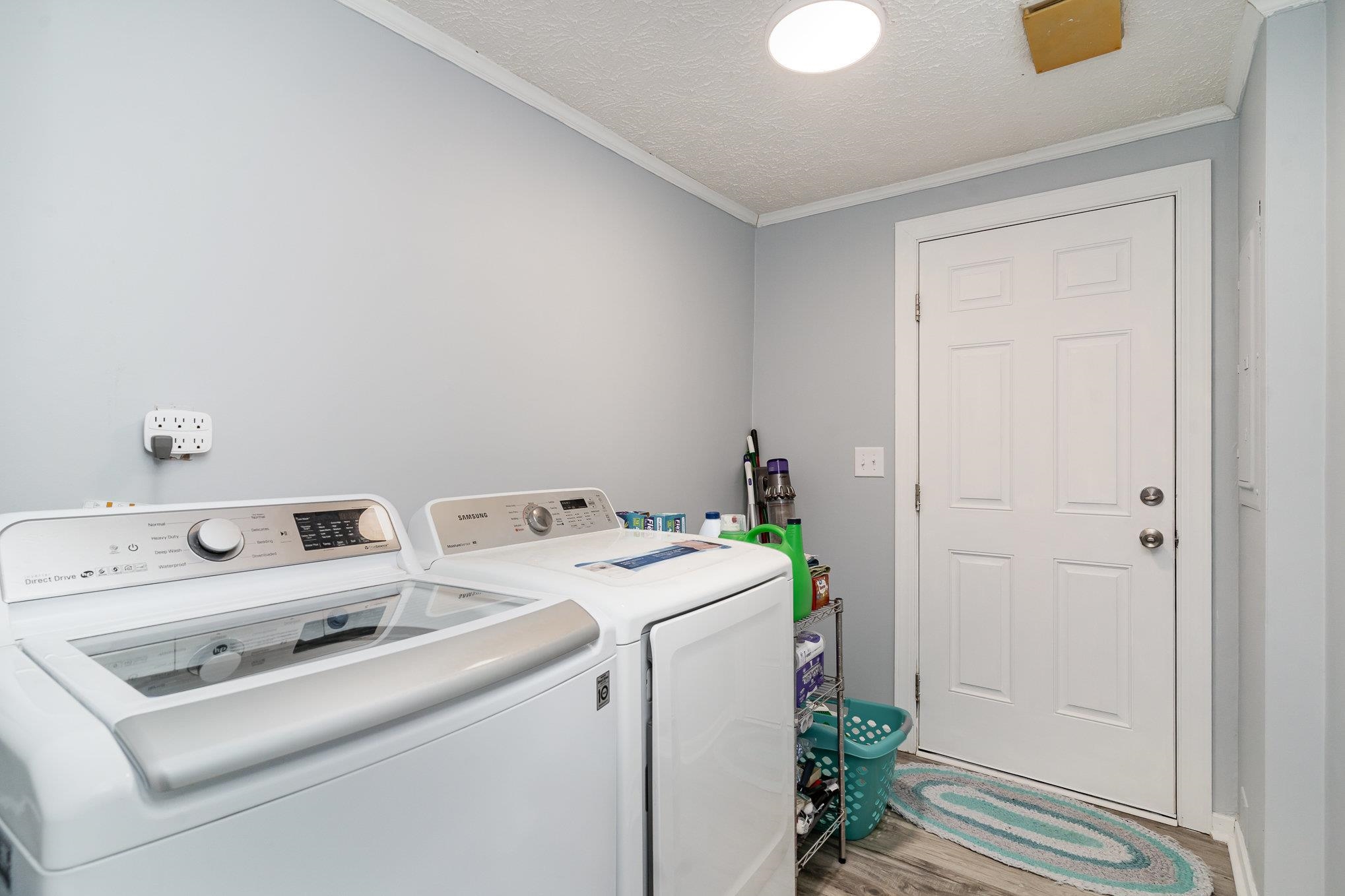 706 Oliver Drive Murrells Inlet, SC 29576 - Photo 19 of 29 Washroom with a textured ceiling, ornamental molding, washer and dryer, and light wood finished floors