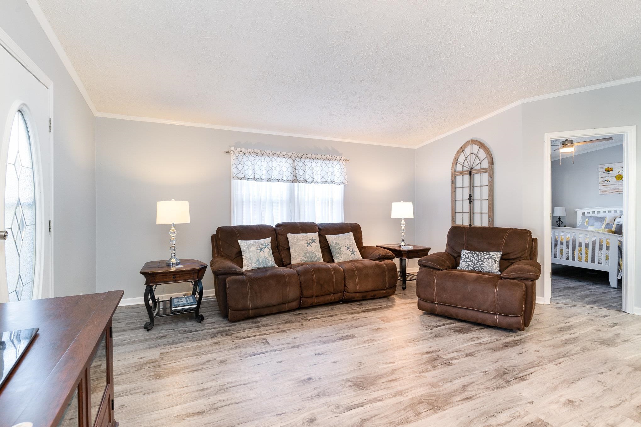 706 Oliver Drive Murrells Inlet, SC 29576 - Photo 4 of 29 Living area with ornamental molding, light wood finished floors, a textured ceiling, and ceiling fan