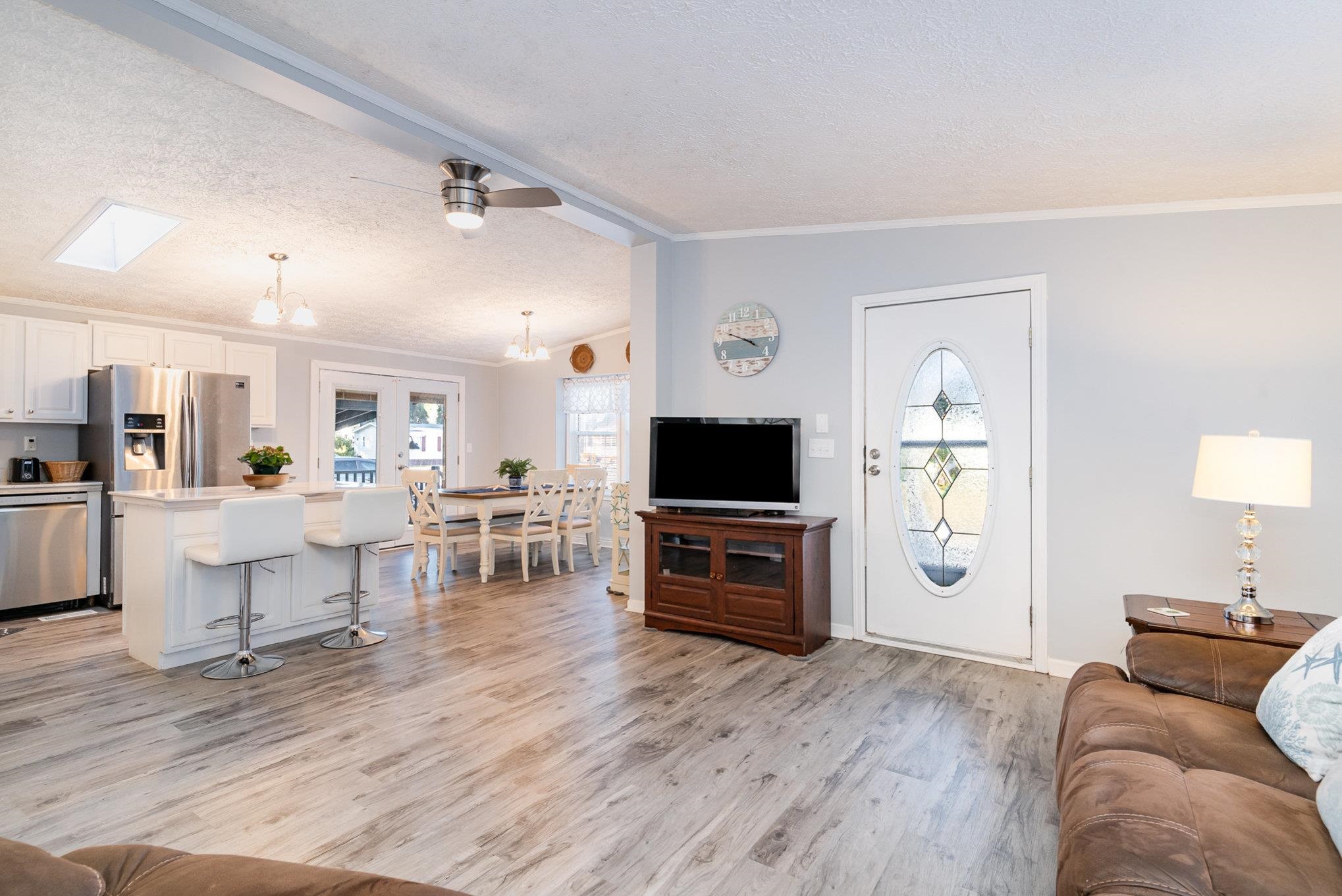 706 Oliver Drive Murrells Inlet, SC 29576 - Photo 5 of 29 Living area featuring lofted ceiling, a ceiling fan, light wood-style flooring, a textured ceiling, and a chandelier
