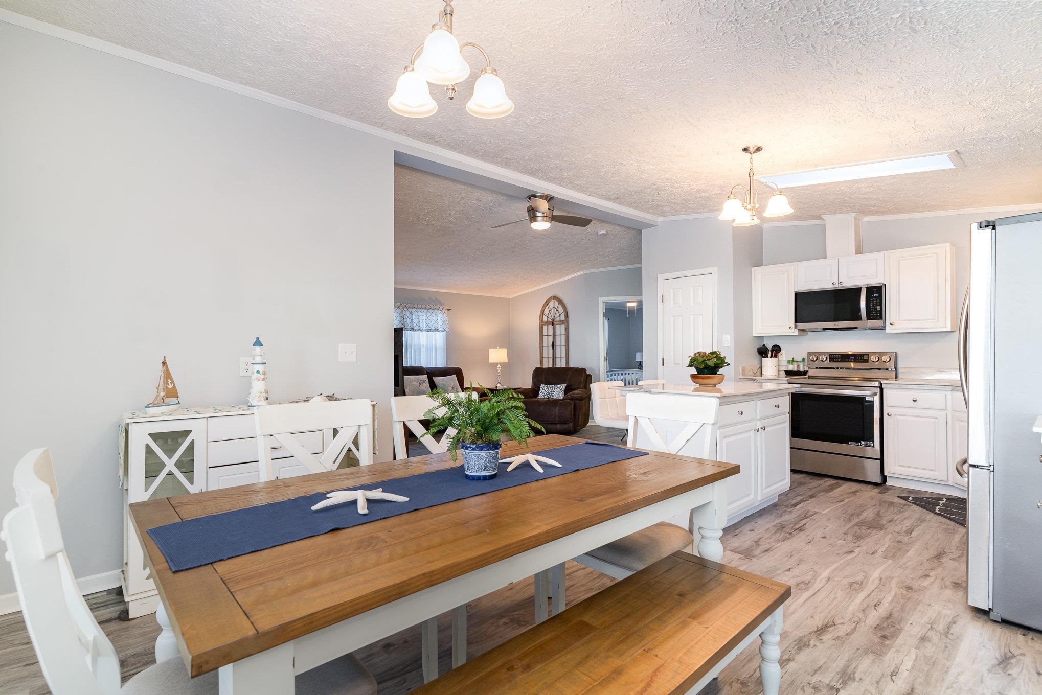 706 Oliver Drive Murrells Inlet, SC 29576 - Photo 8 of 29 Dining area with a textured ceiling, a chandelier, light wood-style floors, ceiling fan, and vaulted ceiling