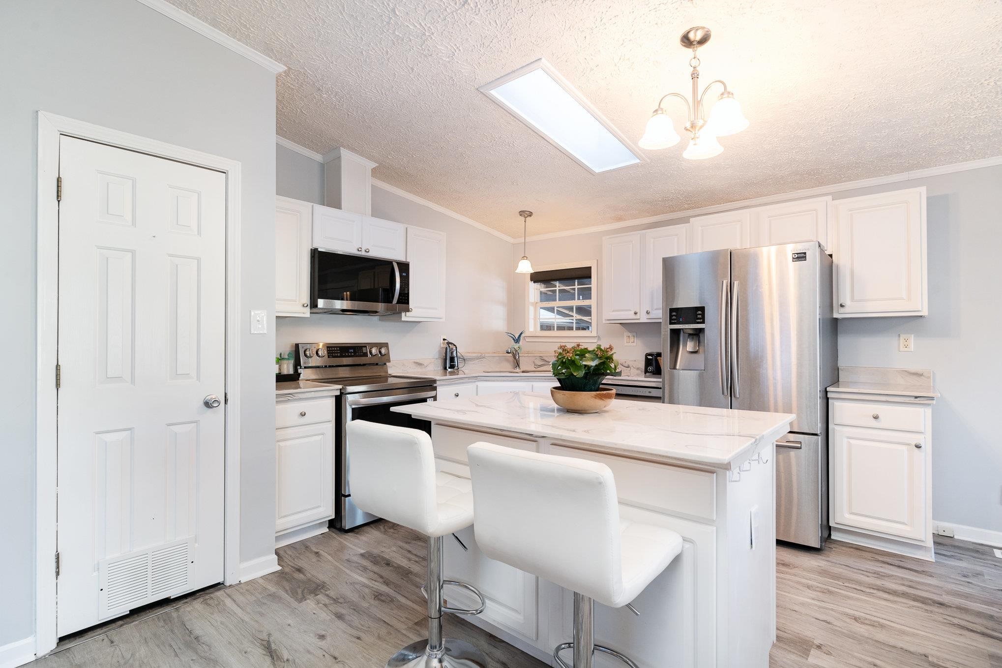 706 Oliver Drive Murrells Inlet, SC 29576 - Photo 9 of 29 Kitchen with stainless steel appliances, pendant lighting, a kitchen breakfast bar, a center island, and ornamental molding