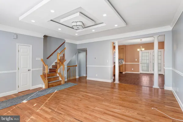 a view of a livingroom with wooden floor and stairs
