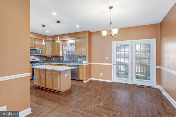 a kitchen with granite countertop a stove a sink and a wooden floors