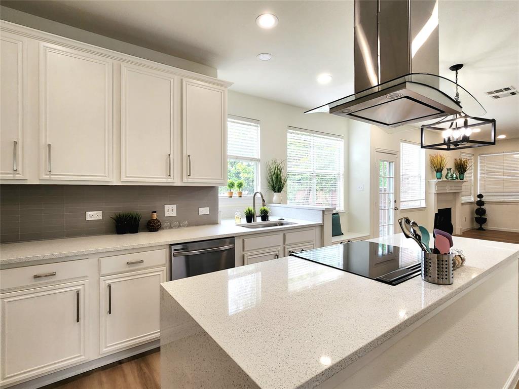 a kitchen with stainless steel appliances granite countertop a sink a stove and white cabinets