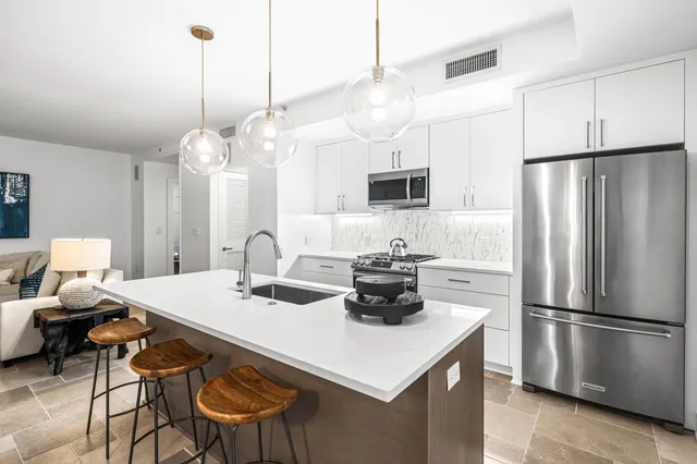 a kitchen with stainless steel appliances a stove microwave and sink
