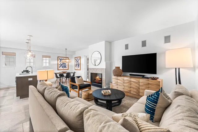 a living room with furniture a flat screen tv and a fireplace