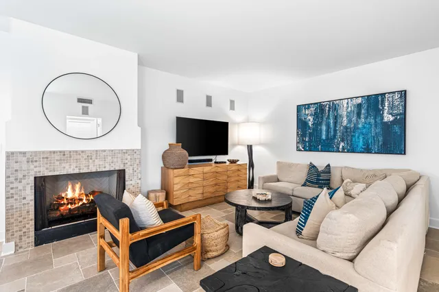 a living room with furniture a flat screen tv and a fireplace