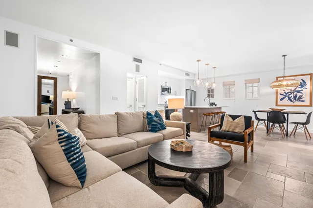 a kitchen with stainless steel appliances kitchen island granite countertop a sink a stove a dining table and chairs