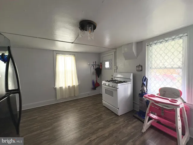 a room with a chair and white cabinets