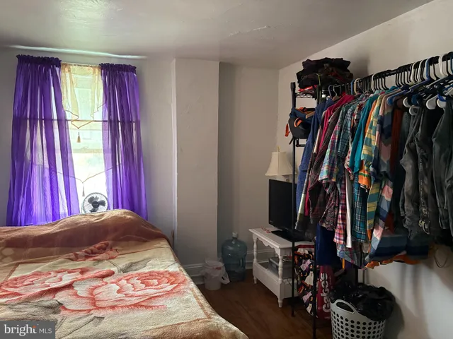 a view of a bedroom with clothes and shoes