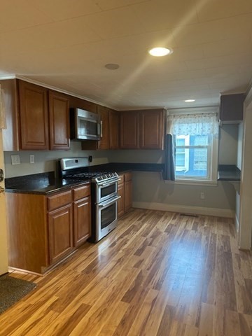 19 Water Street, Unit 1 Milford, MA 01757 - Photo 9 of 15 a kitchen with stainless steel appliances granite countertop a stove a sink and a microwave