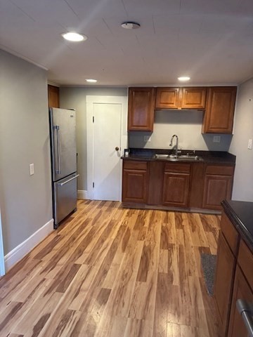 19 Water Street, Unit 1 Milford, MA 01757 - Photo 10 of 15 a large kitchen with granite countertop a refrigerator and a stove top oven