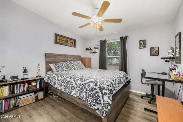 a bedroom with a bed a dresser and book shelfs
