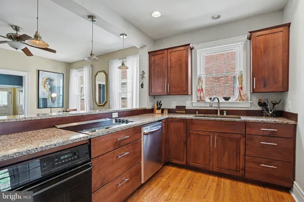 a kitchen with stainless steel appliances granite countertop wooden cabinets and a stove top oven