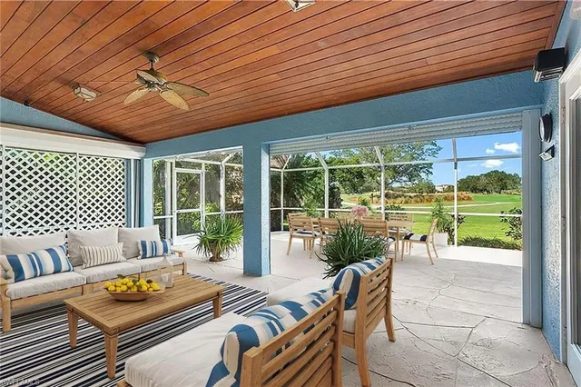 a view of a porch with chairs and table under an umbrella