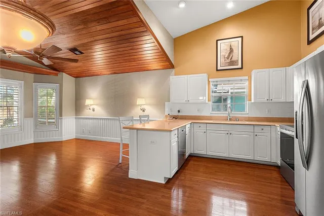 a kitchen with a refrigerator and white cabinets