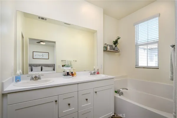 a bathroom with 2 sink tub and a mirror