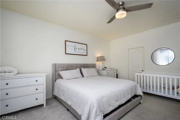 a bedroom with a bed a window and a chandelier