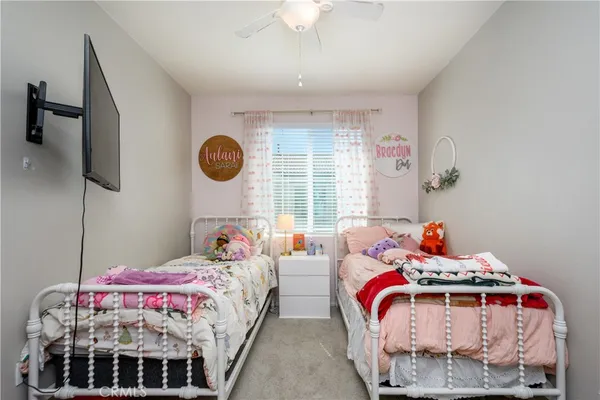a bedroom with two beds and a chandelier