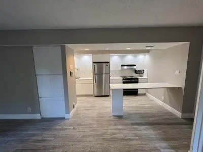 a view of kitchen with refrigerator and wooden floor