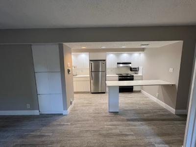 545 Trace Circle, Unit 204 Deerfield Beach, FL 33441 - Photo 2 of 10 a view of kitchen with refrigerator and wooden floor