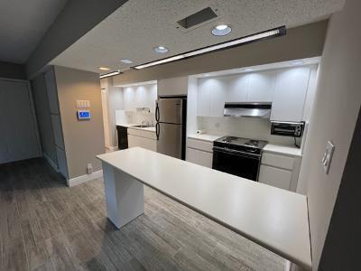 545 Trace Circle, Unit 204 Deerfield Beach, FL 33441 - Photo 5 of 10 a kitchen with a refrigerator and a stove top oven