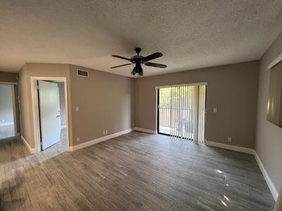 545 Trace Circle, Unit 204 Deerfield Beach, FL 33441 - Photo 6 of 10 wooden floor in an empty room with a window