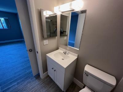 545 Trace Circle, Unit 204 Deerfield Beach, FL 33441 - Photo 8 of 10 a bathroom with a toilet sink and mirror