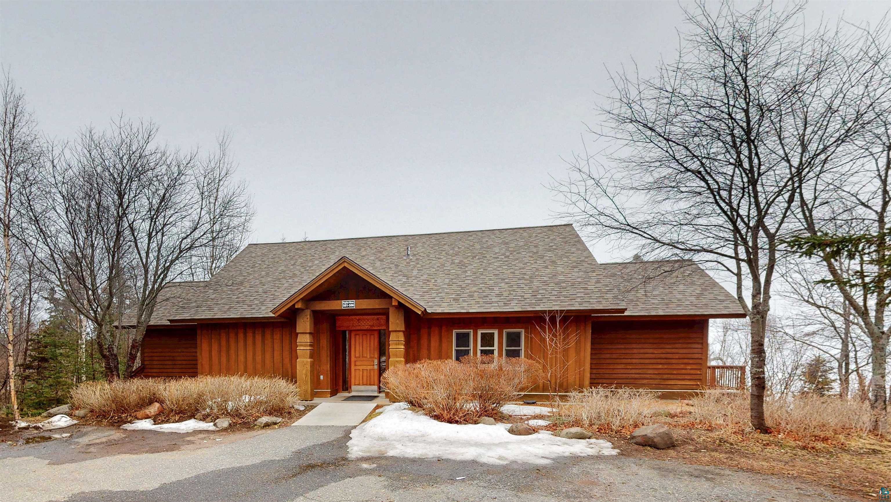 504-506 Poplar River Road, Unit 505 Lutsen, MN 55612 - Photo 23 of 39 Wood-sided residence featuring a covered entry porch supported by substantial wood columns