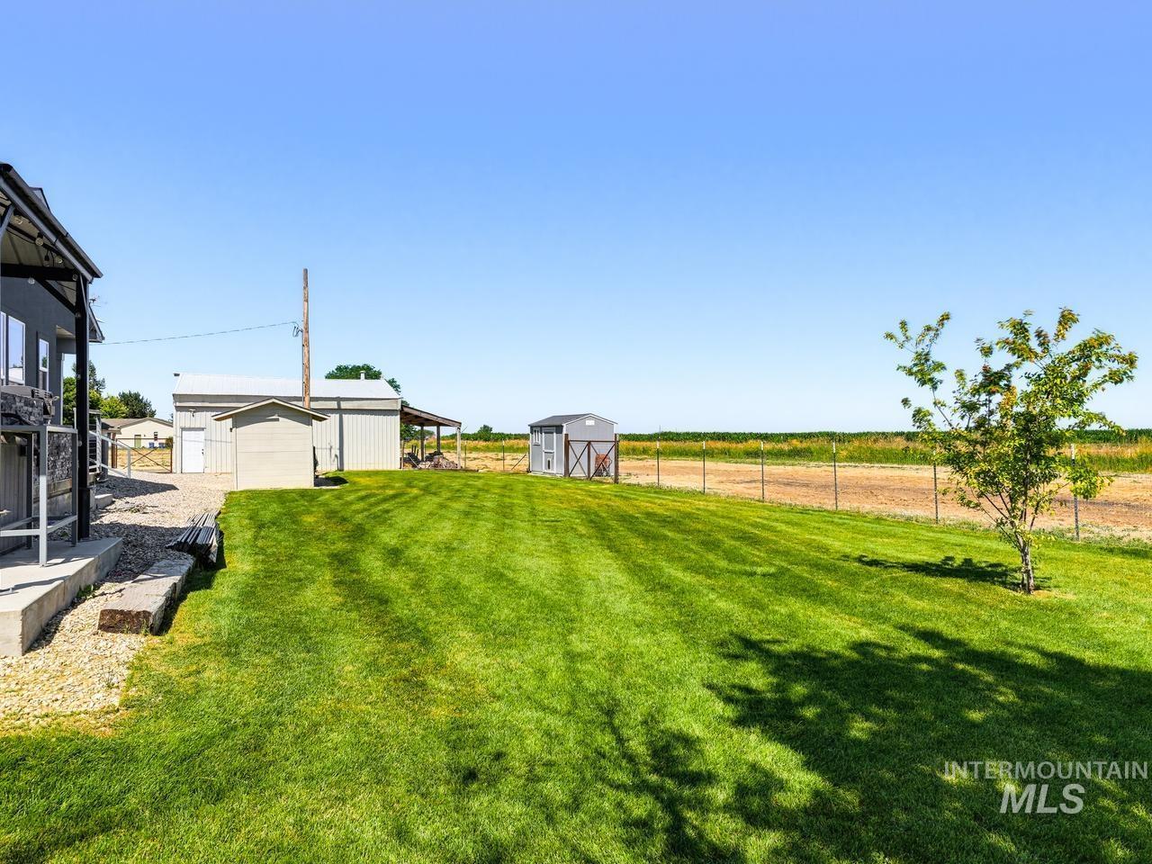 4950 West Columbia Road Nampa, ID 83687 - Photo 43 of 50 Expansive green lawn with visible mow lines, featuring a small tree and a fenced perimeter