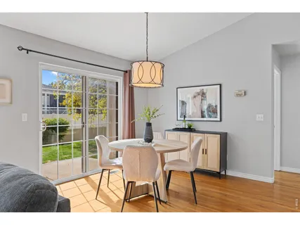 a dining room with furniture a chandelier and wooden floor