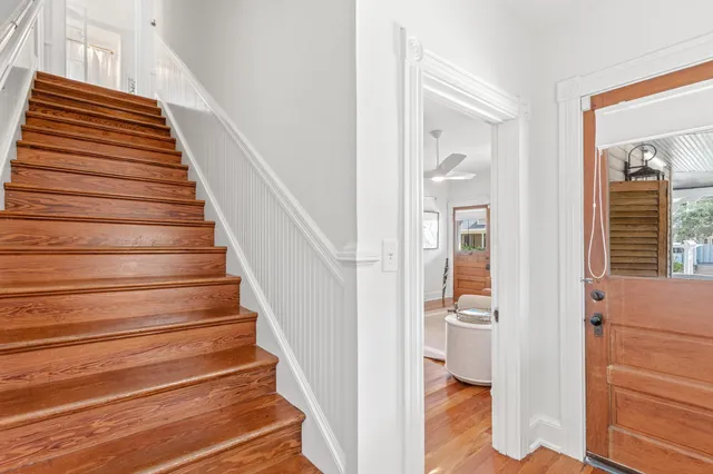a view of staircase with wooden floor and white walls