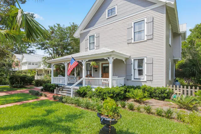 a kitchen with stainless steel appliances kitchen island granite countertop a stove a sink dishwasher and white cabinets with wooden floor