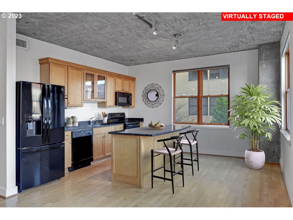 411 Northwest Flanders Street, Unit 401 Portland, OR 97209 - Photo 12 of 38 a open kitchen with stainless steel appliances granite countertop a refrigerator a stove a sink dishwasher with a dining table and chairs