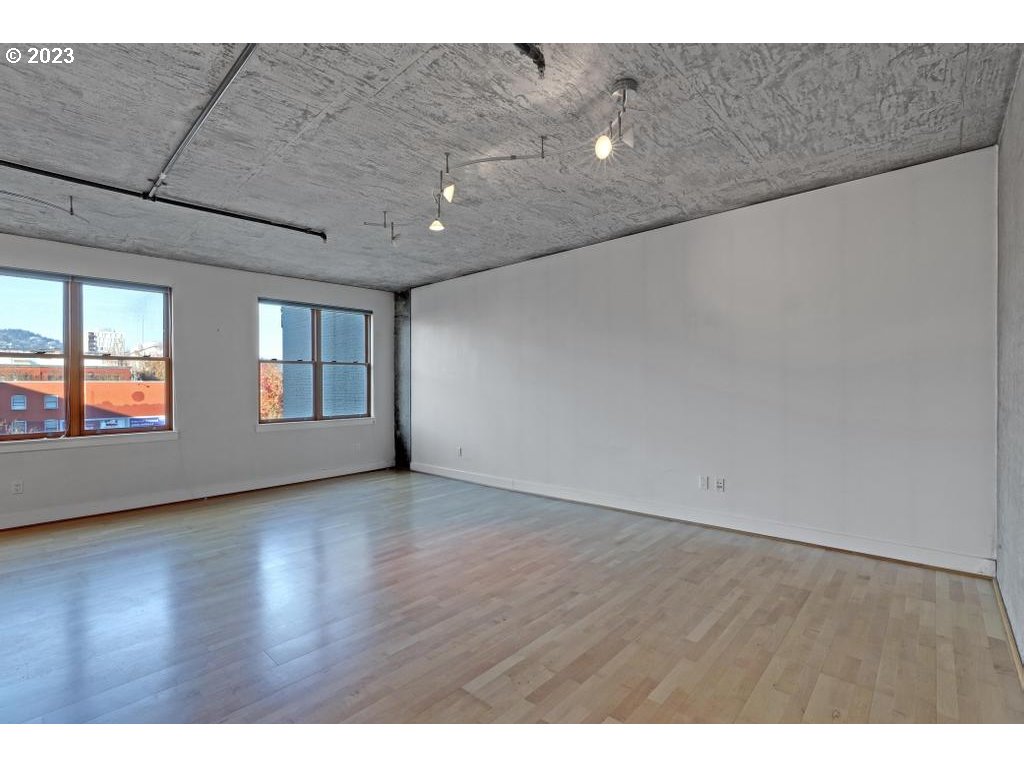 411 Northwest Flanders Street, Unit 401 Portland, OR 97209 - Photo 18 of 38 a view of an empty room with wooden floor and a window