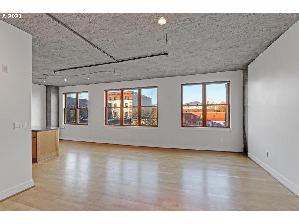 411 Northwest Flanders Street, Unit 401 Portland, OR 97209 - Photo 20 of 38 a view of an empty room with window and wooden floor