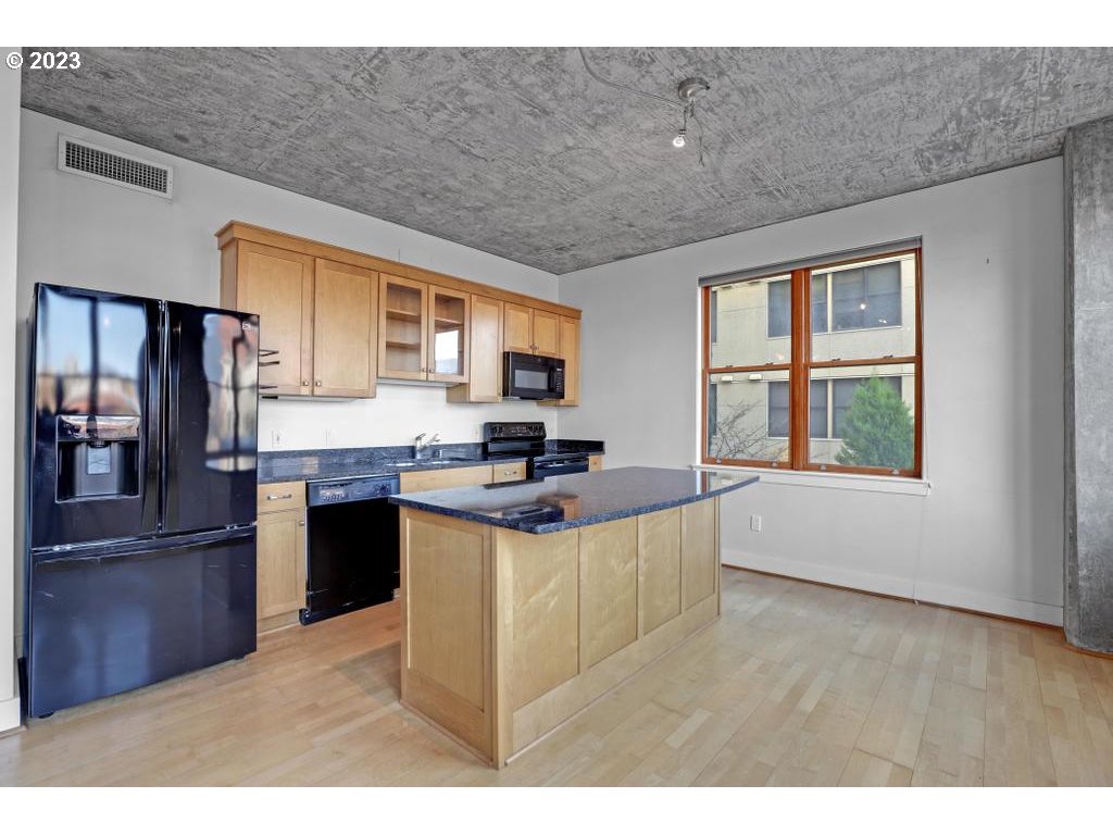411 Northwest Flanders Street, Unit 401 Portland, OR 97209 - Photo 23 of 38 a kitchen with stainless steel appliances granite countertop a stove a refrigerator and a sink