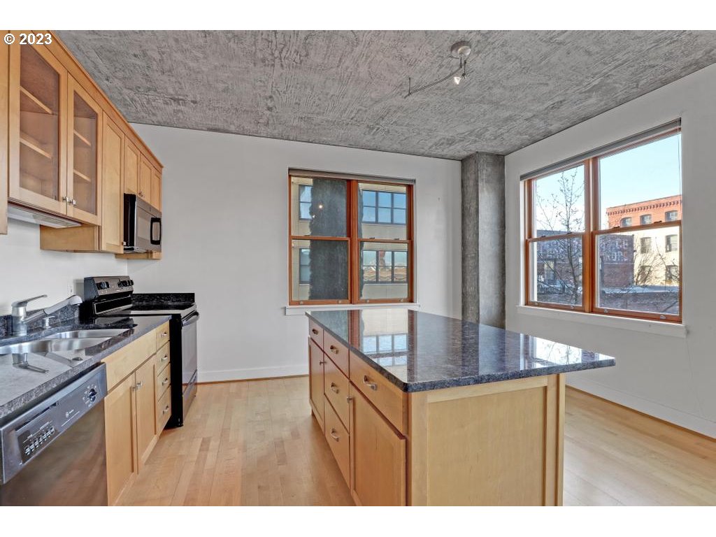 411 Northwest Flanders Street, Unit 401 Portland, OR 97209 - Photo 27 of 38 a kitchen with stainless steel appliances granite countertop a sink stove and cabinets