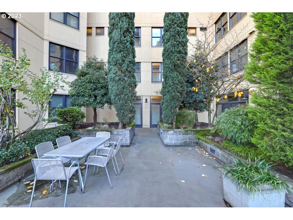 411 Northwest Flanders Street, Unit 401 Portland, OR 97209 - Photo 35 of 38 a view of a patio with table and chairs and potted plants