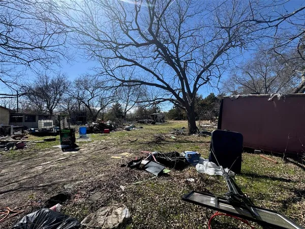 a view of a backyard with a table and chairs under a large tree