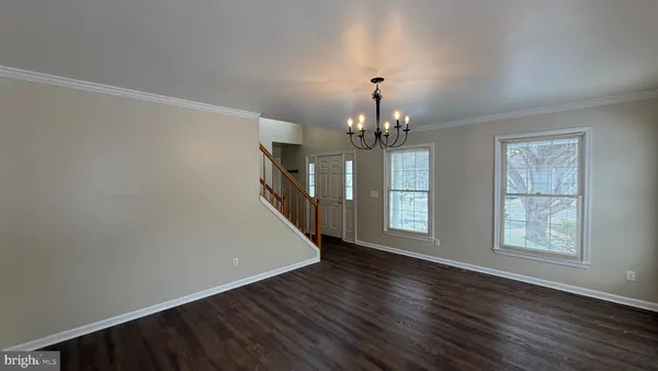 a view of a livingroom with wooden floor and chandelier